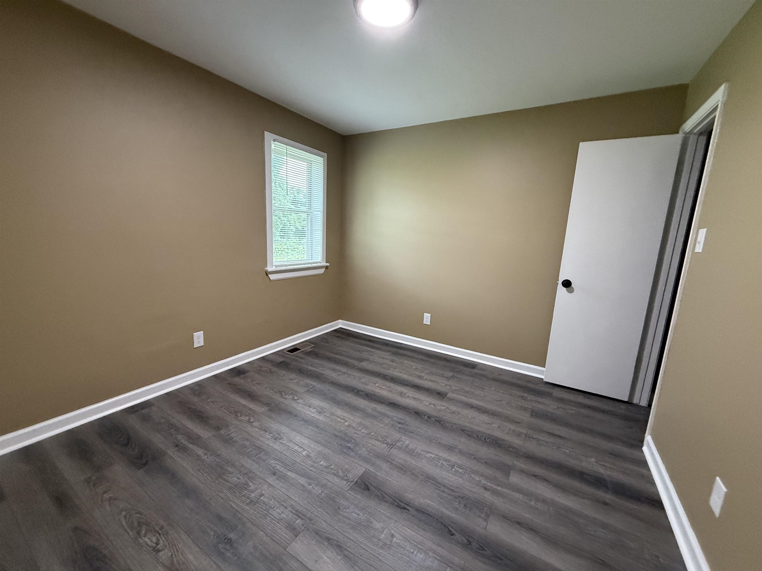 62 Cinnamon Drive, Unit LEFT Jackson, TN 38305 - Photo 7 of 8 an empty room with wooden floor and windows