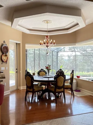 a dining room with furniture large windows and wooden floor