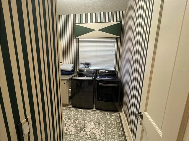a kitchen with a sink and a washing machine in a chair