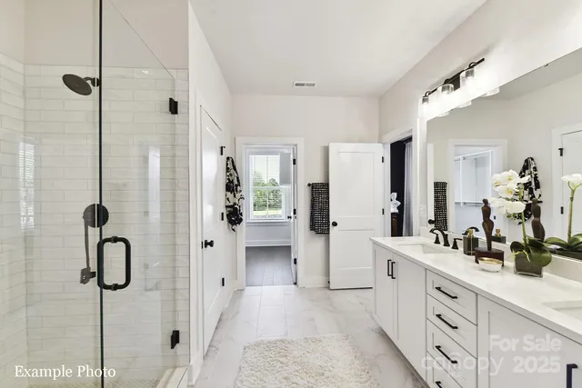 a spacious bathroom with a double vanity sink a mirror a shower and a bathtub
