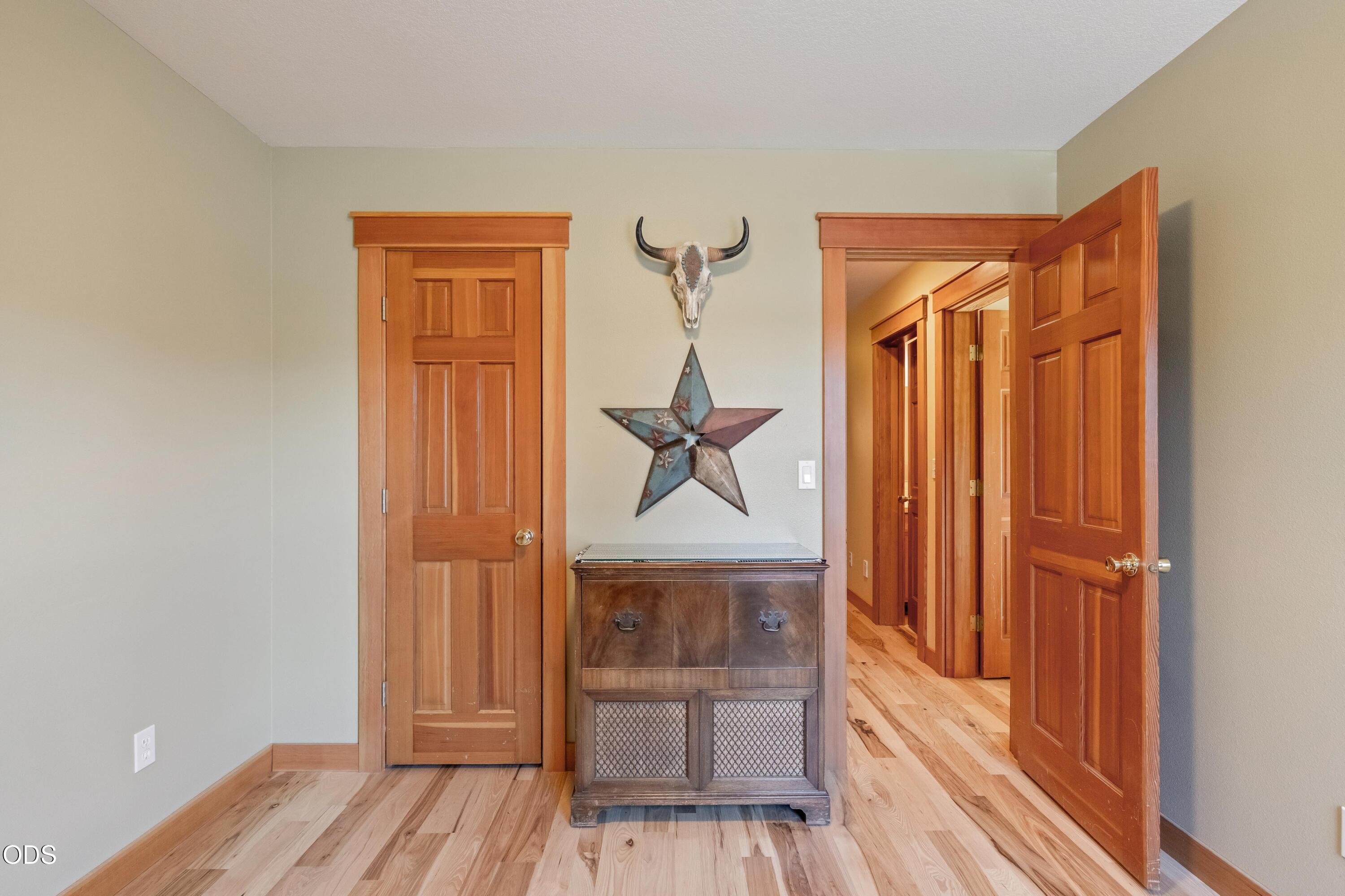 13753 South Sego Lily Road Powell Butte, OR 97753 - Photo 16 of 46 a bedroom with a bed and wooden floor