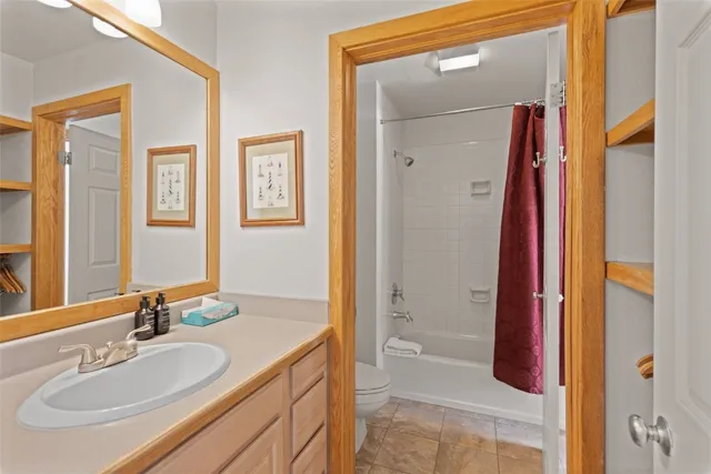 a bathroom with a granite countertop sink a mirror and a shower