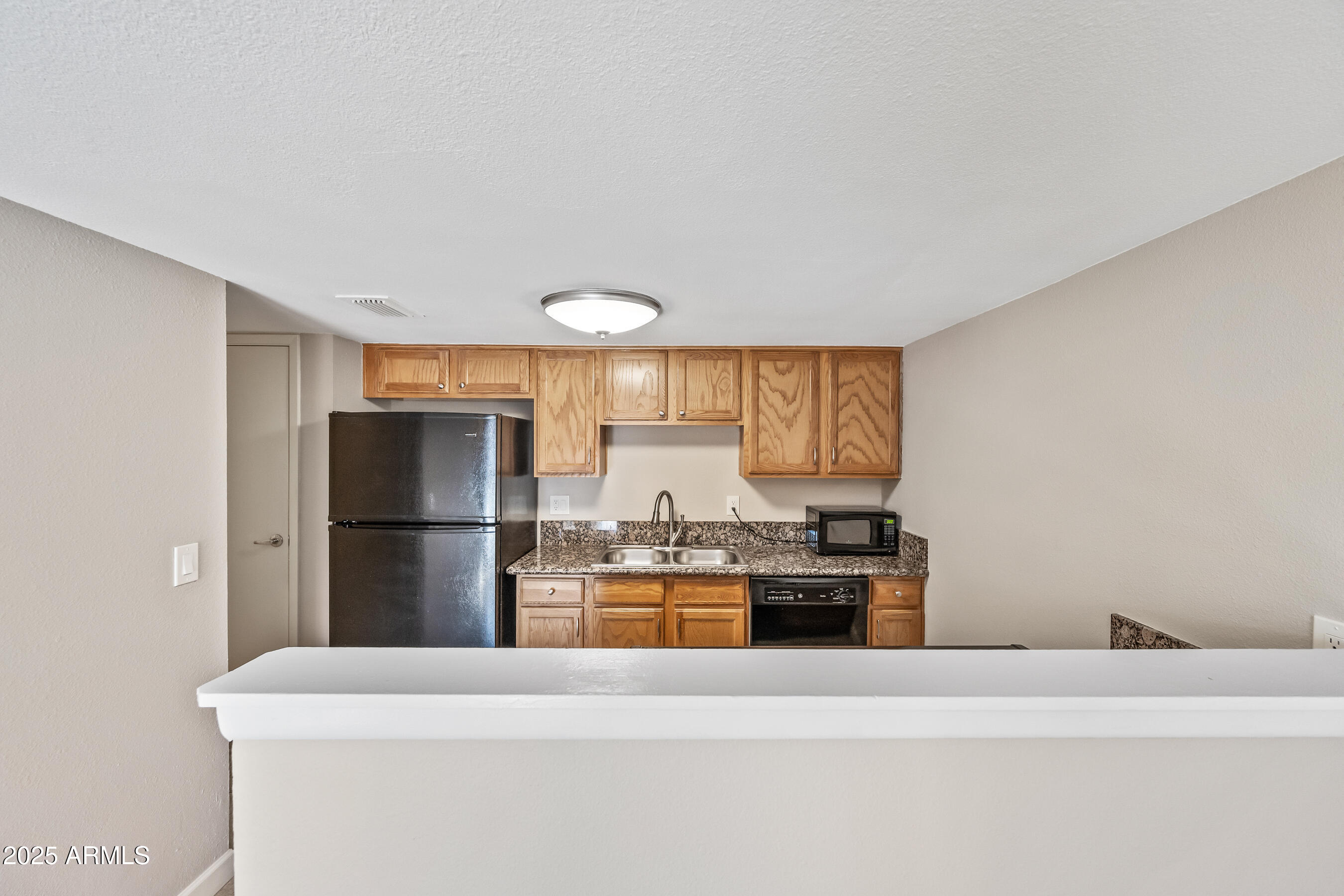 3511 East Baseline Road, Unit 1147 Phoenix, AZ 85042 - Photo 9 of 37 a kitchen with a refrigerator and a stove top oven