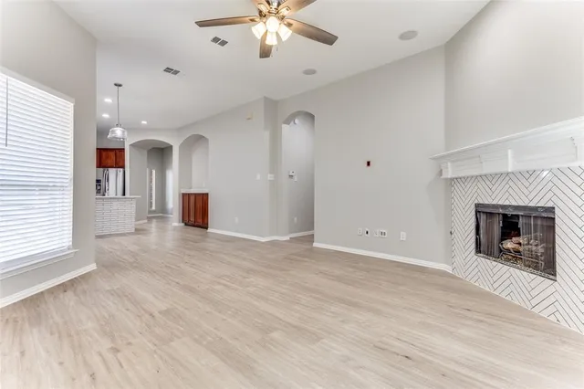 an empty room with windows and a fireplace
