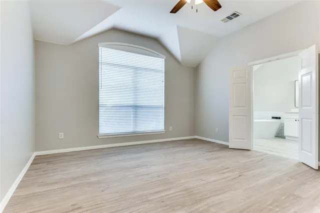 an empty room with wooden floor and a window
