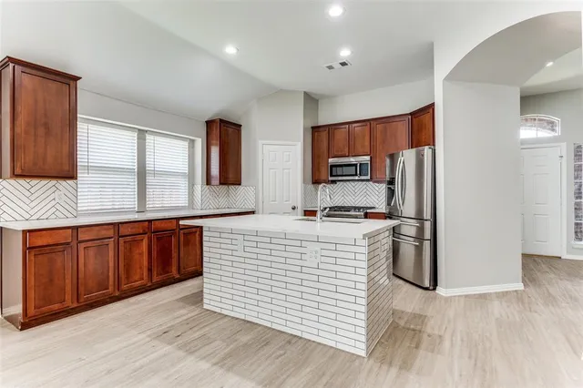 a large kitchen with stainless steel appliances granite countertop a sink refrigerator and microwave