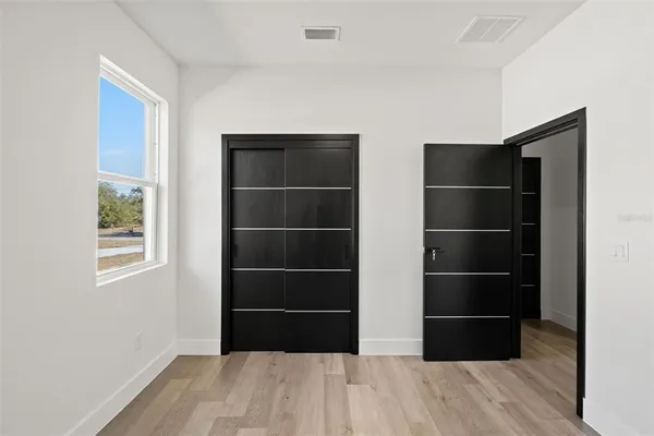 a room with a closet a window and wooden floor