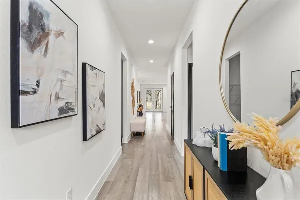 a view of a hallway with furniture and wooden floor