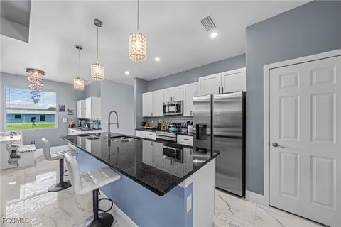 a kitchen with stainless steel appliances granite countertop a sink refrigerator and microwave