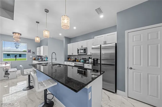 a kitchen with stainless steel appliances granite countertop a sink refrigerator and microwave