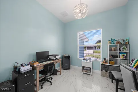 a view of a workspace with furniture and a window