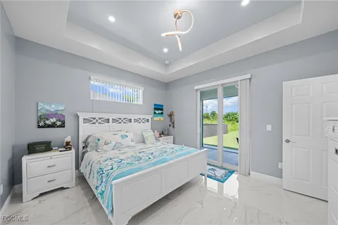 a bedroom with a bed a window and a chandelier