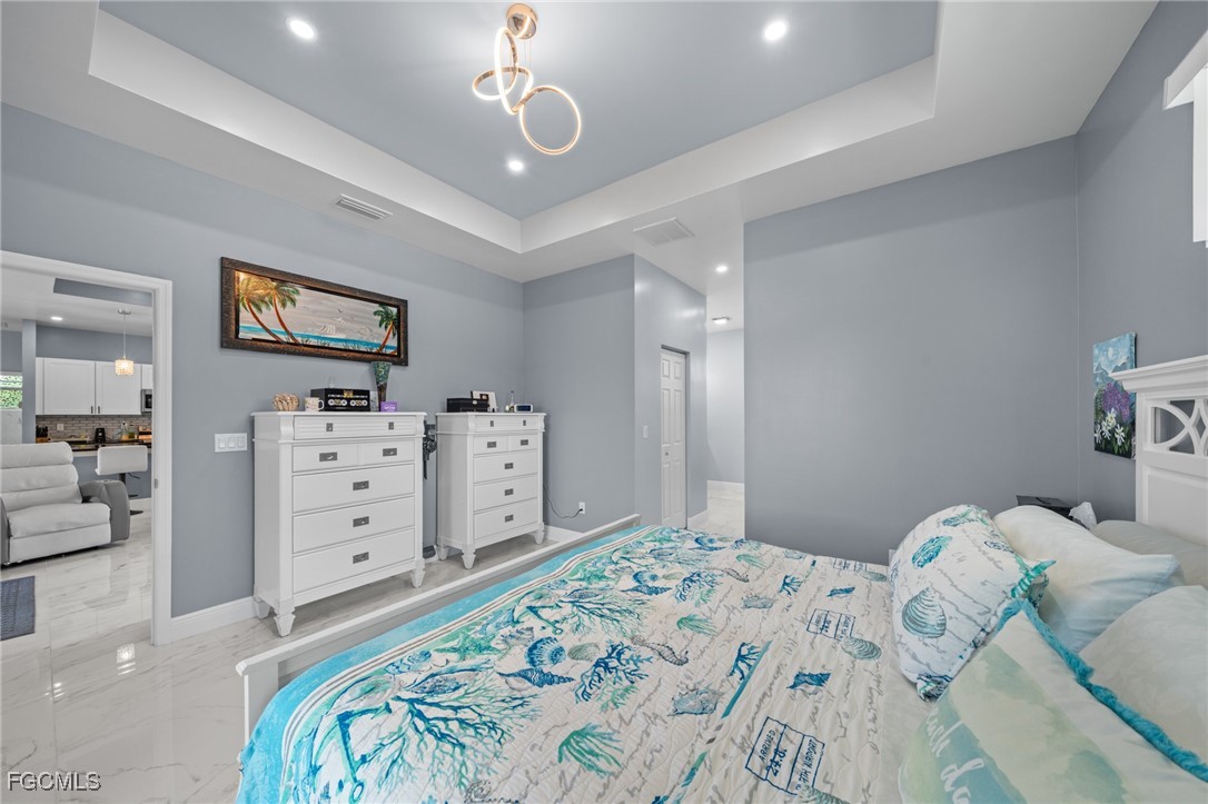 2906 9th Street Southwest Lehigh Acres, FL 33976 - Photo 16 of 30 a bedroom with a bed and wooden floor