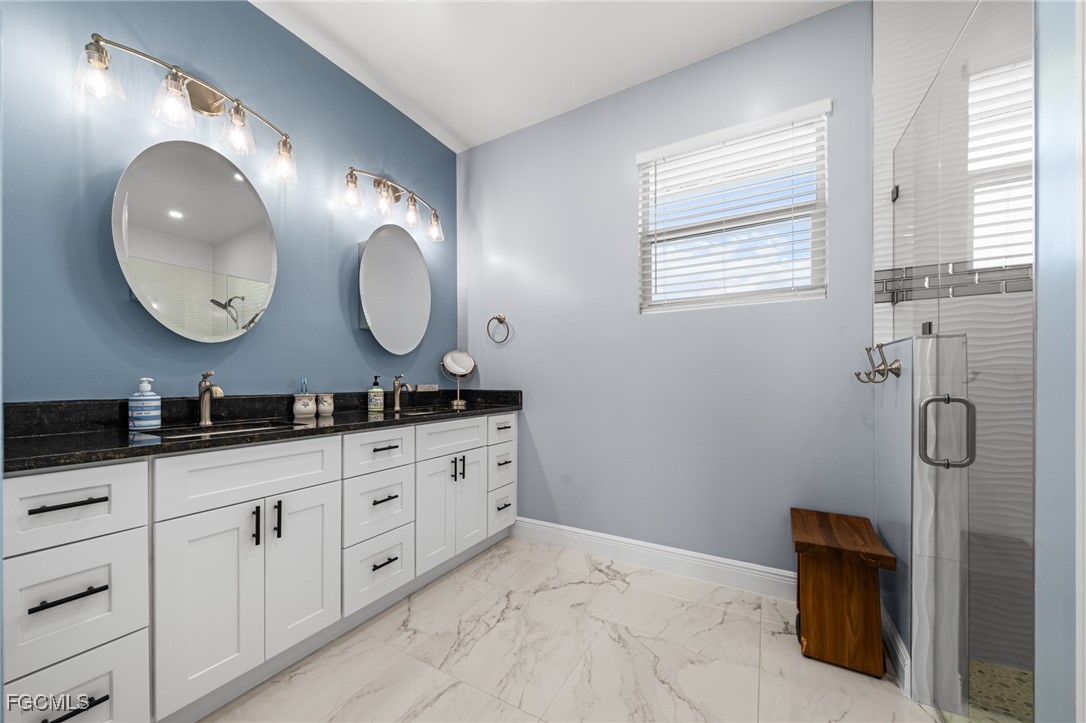 2906 9th Street Southwest Lehigh Acres, FL 33976 - Photo 17 of 30 a bathroom with double sink and a mirror