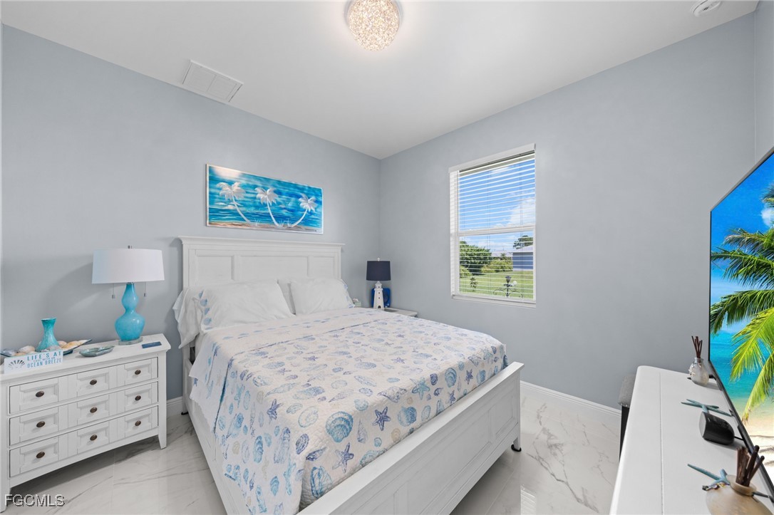 2906 9th Street Southwest Lehigh Acres, FL 33976 - Photo 21 of 30 a bedroom with a bed dresser and a window