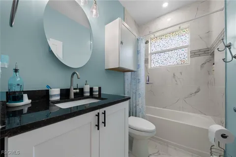 a bathroom with a granite countertop sink toilet and shower