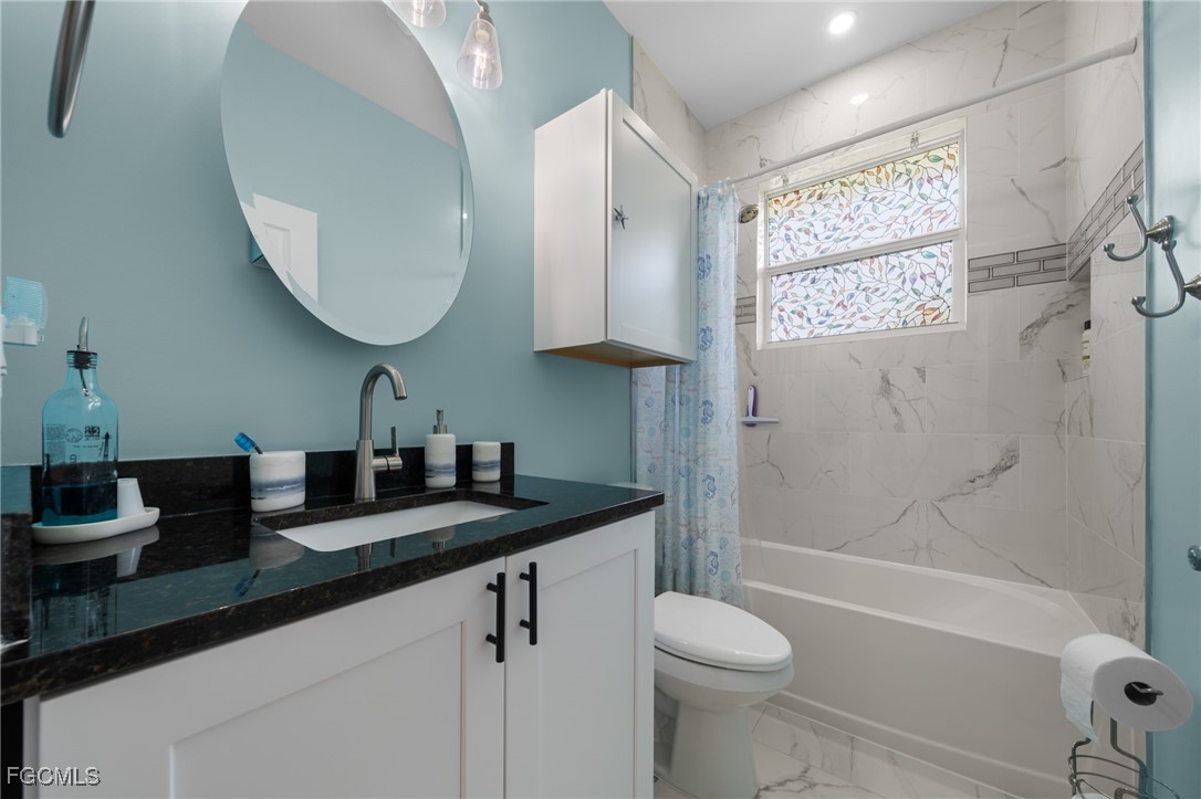 2906 9th Street Southwest Lehigh Acres, FL 33976 - Photo 22 of 30 a bathroom with a granite countertop sink toilet and shower