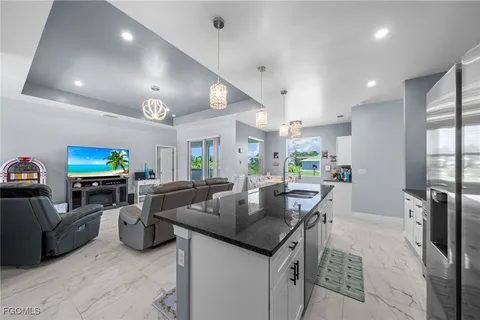 a kitchen with stainless steel appliances granite countertop a sink a stove and a refrigerator