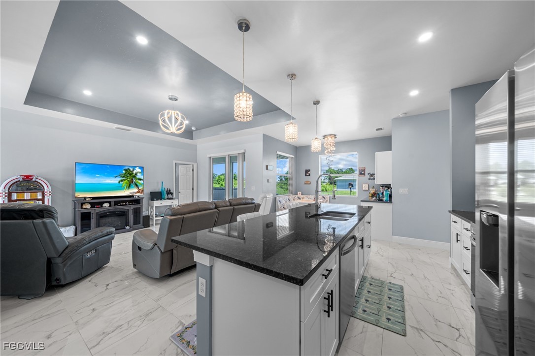 2906 9th Street Southwest Lehigh Acres, FL 33976 - Photo 6 of 30 a kitchen with stainless steel appliances granite countertop a sink a stove and a refrigerator