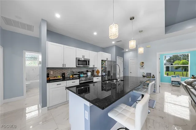 a kitchen with stainless steel appliances granite countertop a sink a stove and a refrigerator