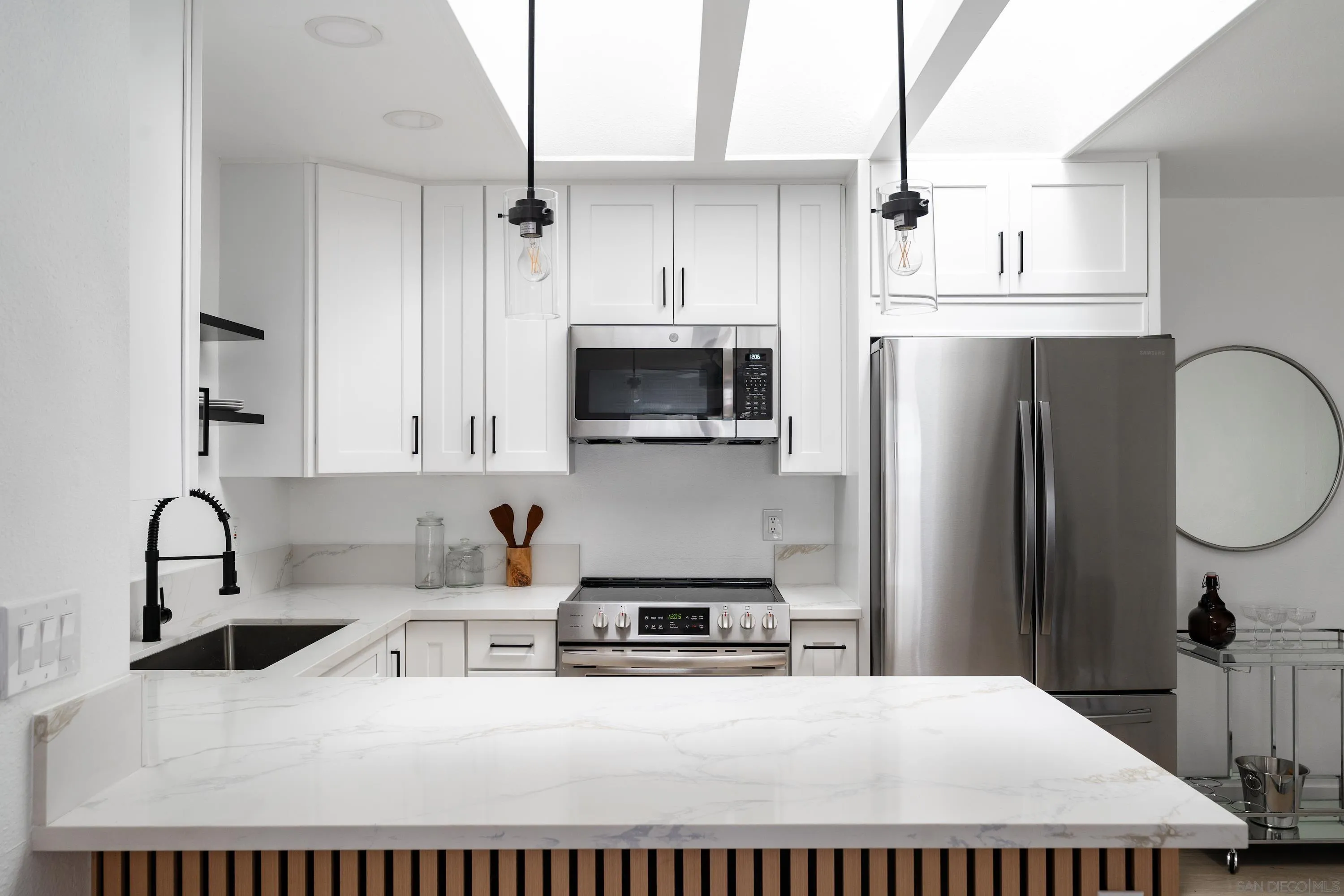 6376 Rancho Mission Road, Unit 402 San Diego, CA 92108 - Photo 11 of 27 a kitchen with kitchen island a sink stainless steel appliances and cabinets