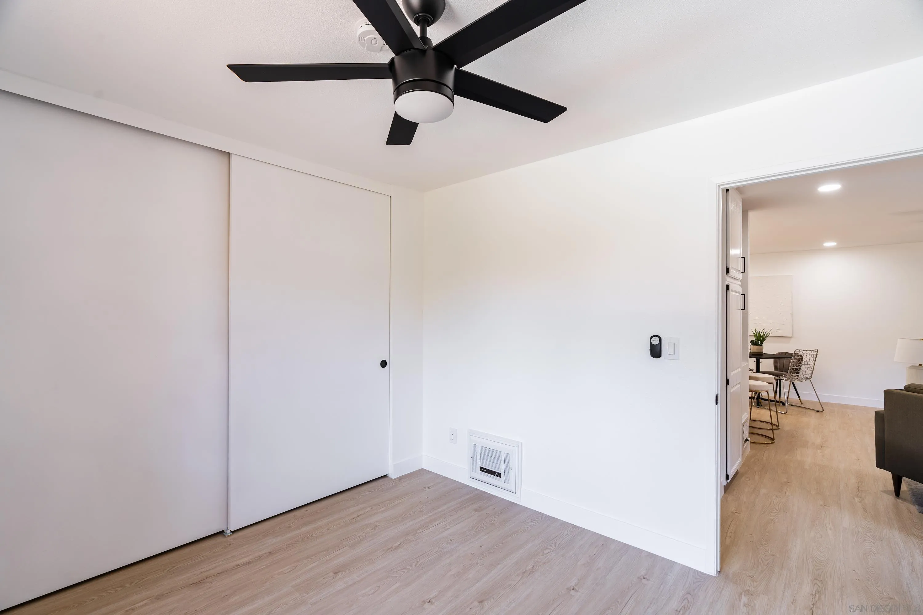 6376 Rancho Mission Road, Unit 402 San Diego, CA 92108 - Photo 19 of 27 an empty room with wooden floor and a ceiling fan
