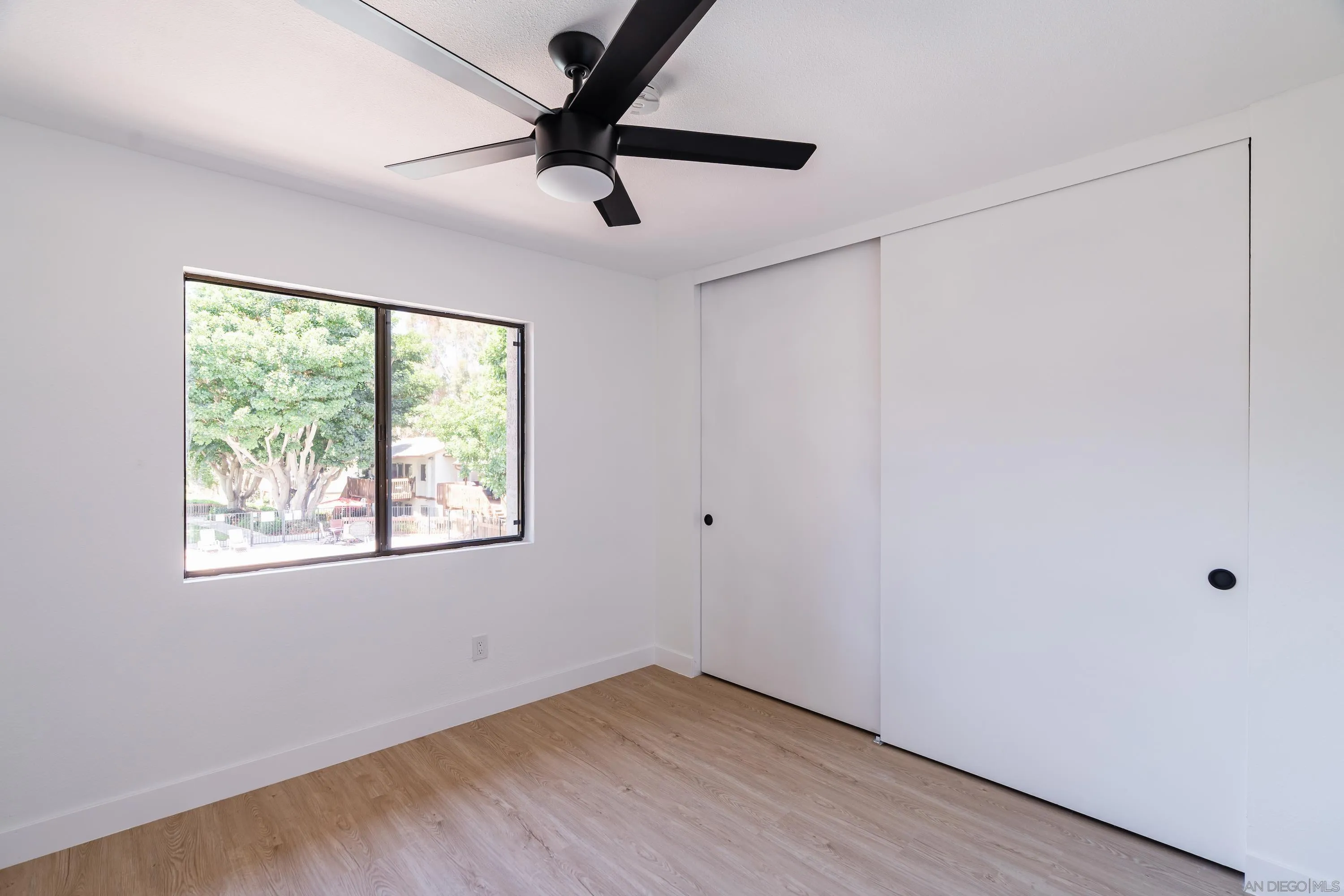 6376 Rancho Mission Road, Unit 402 San Diego, CA 92108 - Photo 20 of 27 a view of an empty room with wooden floor and a window