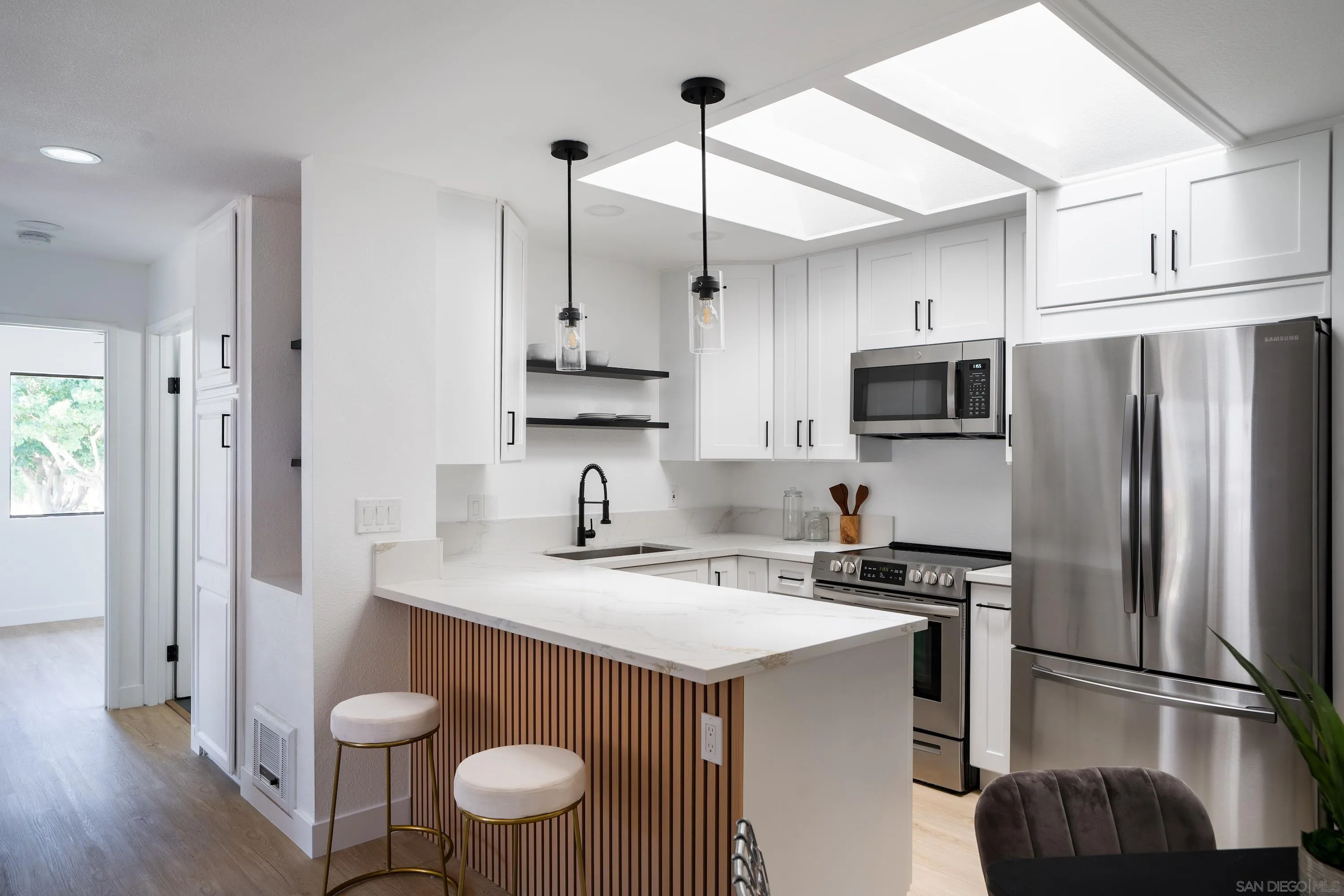 6376 Rancho Mission Road, Unit 402 San Diego, CA 92108 - Photo 5 of 27 a kitchen with stainless steel appliances a sink a stove a refrigerator cabinets and wooden floor