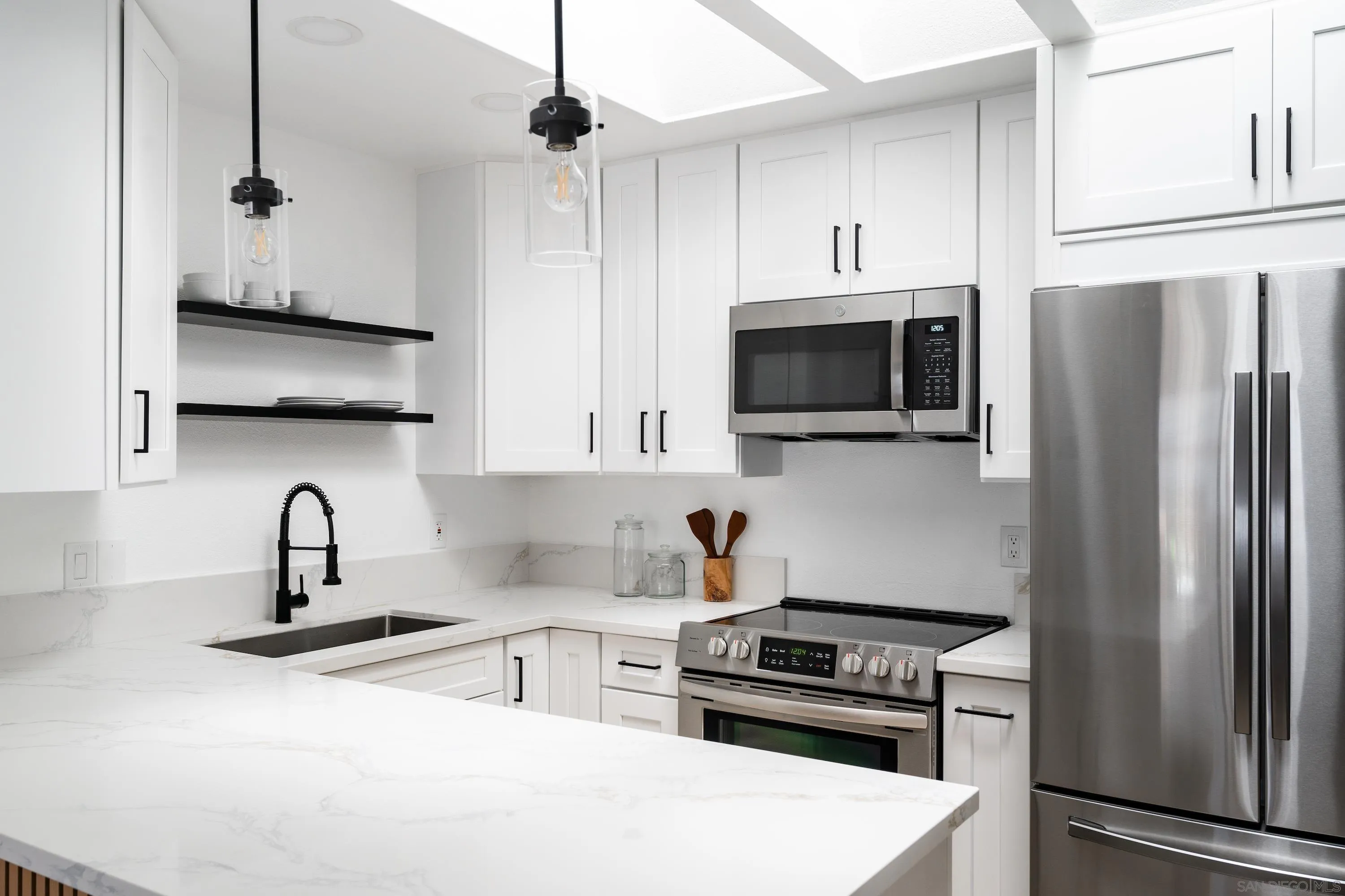 6376 Rancho Mission Road, Unit 402 San Diego, CA 92108 - Photo 10 of 27 a kitchen with stainless steel appliances a stove a sink a refrigerator and cabinets