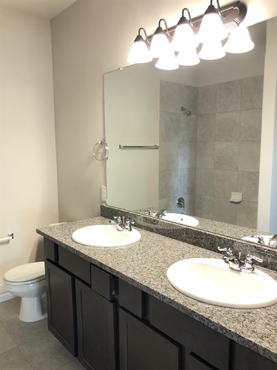 1727 Davidson Ranch Road Georgetown, TX 78626 - Photo 7 of 10 Full bath featuring double vanity, a tile shower, toilet, and a sink