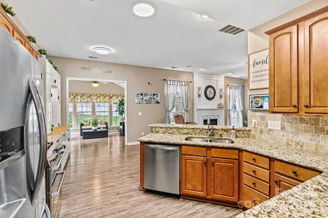 a kitchen with granite countertop a refrigerator stove top oven and sink