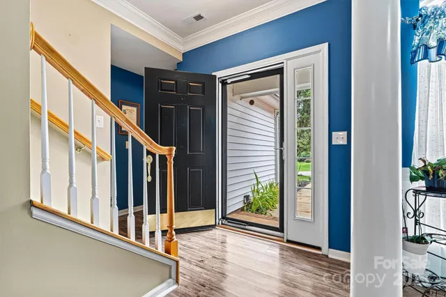a dining room with furniture a chandelier and wooden floor