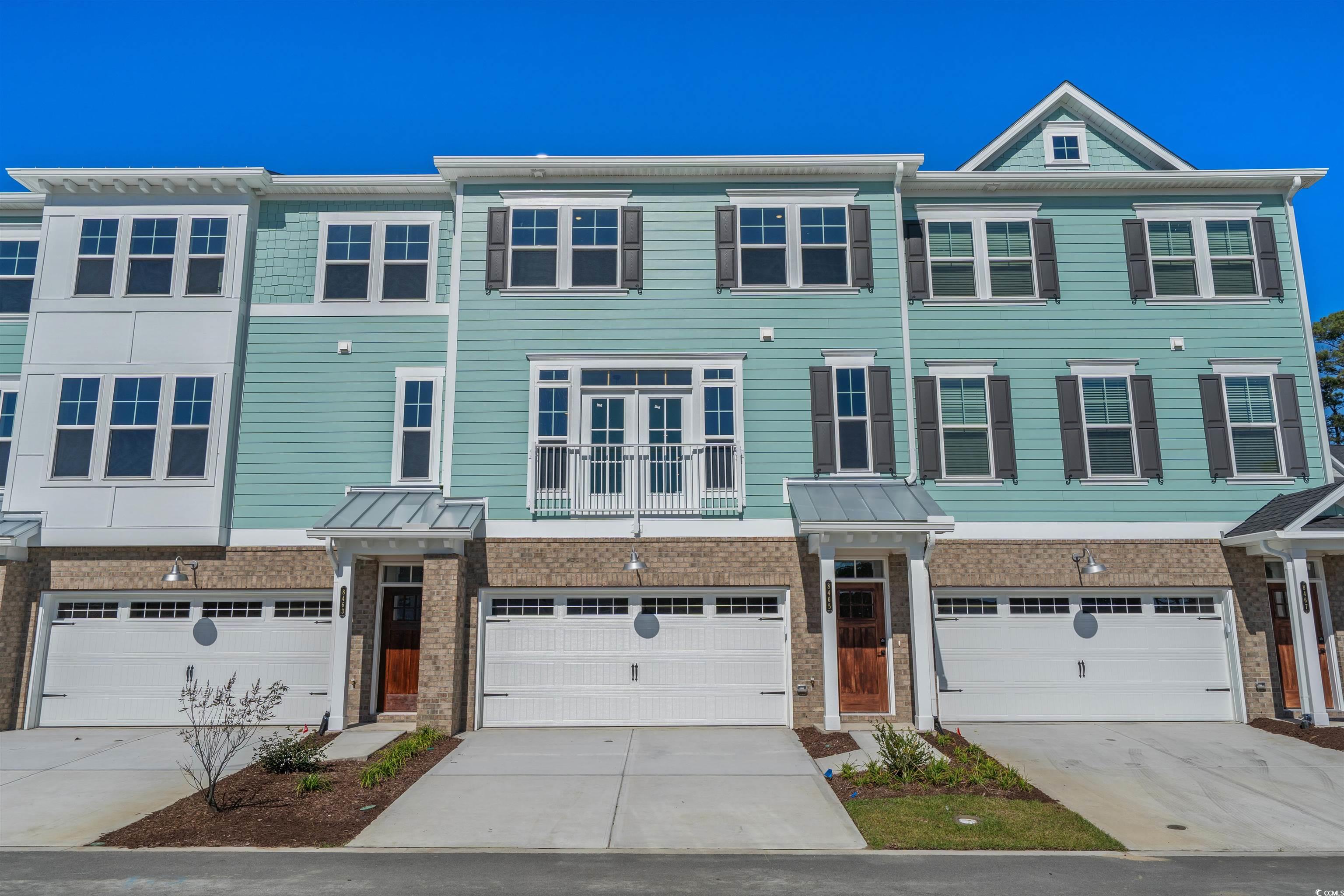 8465 Waltzing Waves Court, Unit 26 Myrtle Beach, SC 29572 - Photo 2 of 40 View of front facade with driveway, brick siding, and a garage