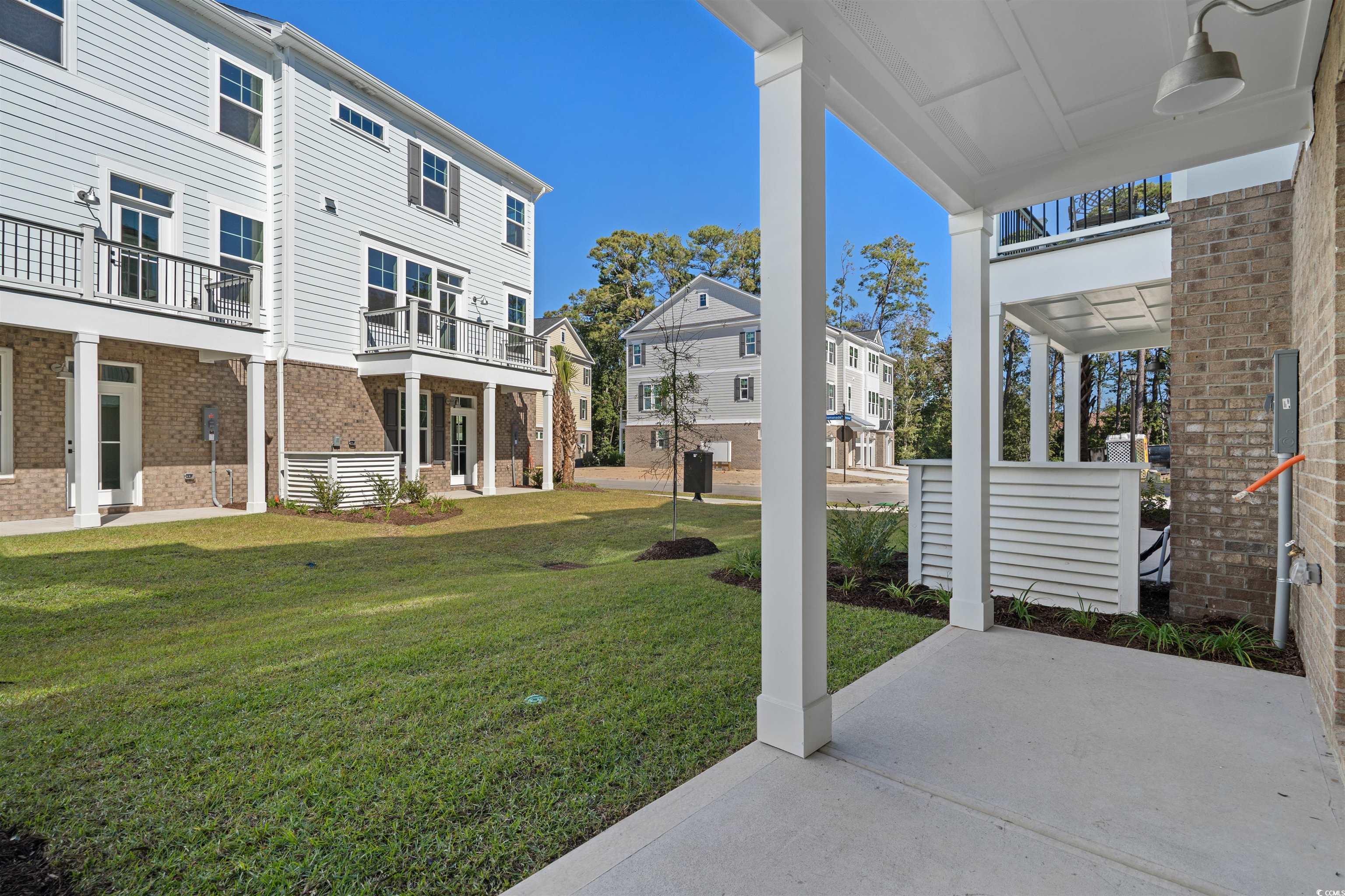 8465 Waltzing Waves Court, Unit 26 Myrtle Beach, SC 29572 - Photo 25 of 40 View of green lawn with a patio, a residential view, and a balcony