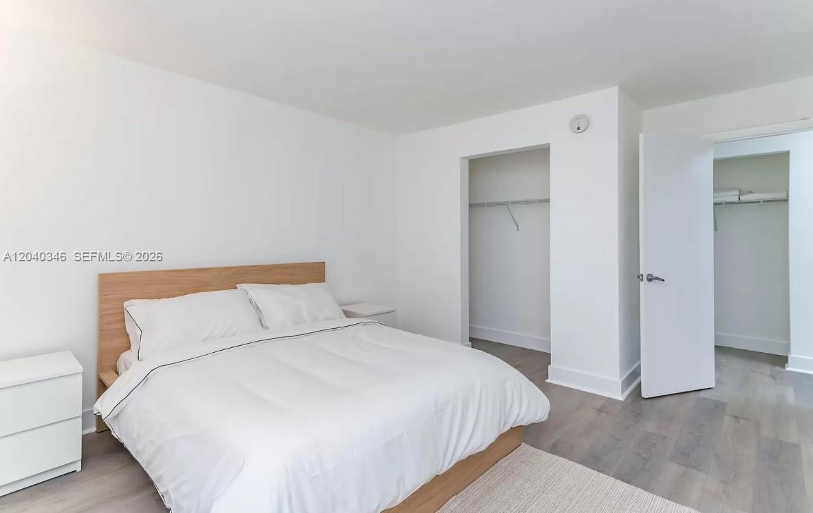 143 Southwest 9th Street, Unit 301 Miami, FL 33130 - Photo 3 of 16 a bedroom with a bed and a night stand
