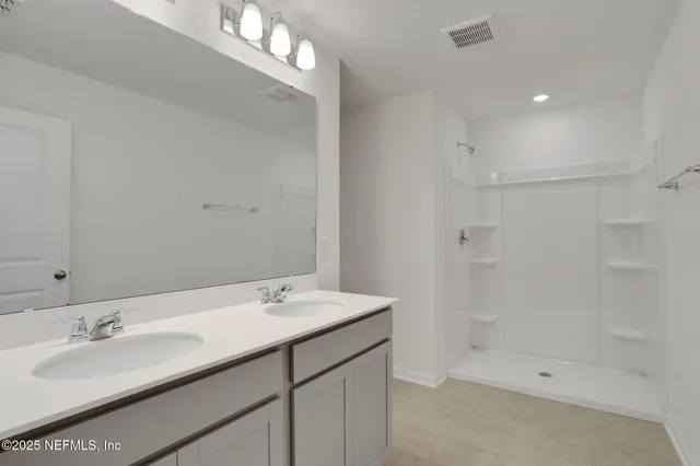 a bathroom with a shower sink and mirror