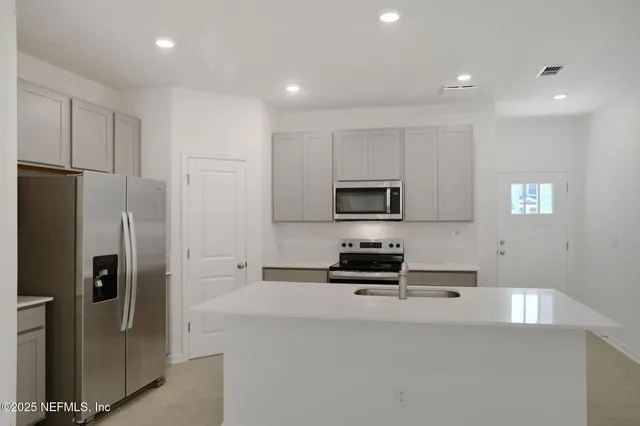 a kitchen with stainless steel appliances a refrigerator stove and microwave