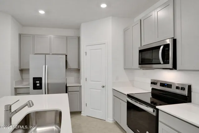 a kitchen with stainless steel appliances a stove microwave and refrigerator