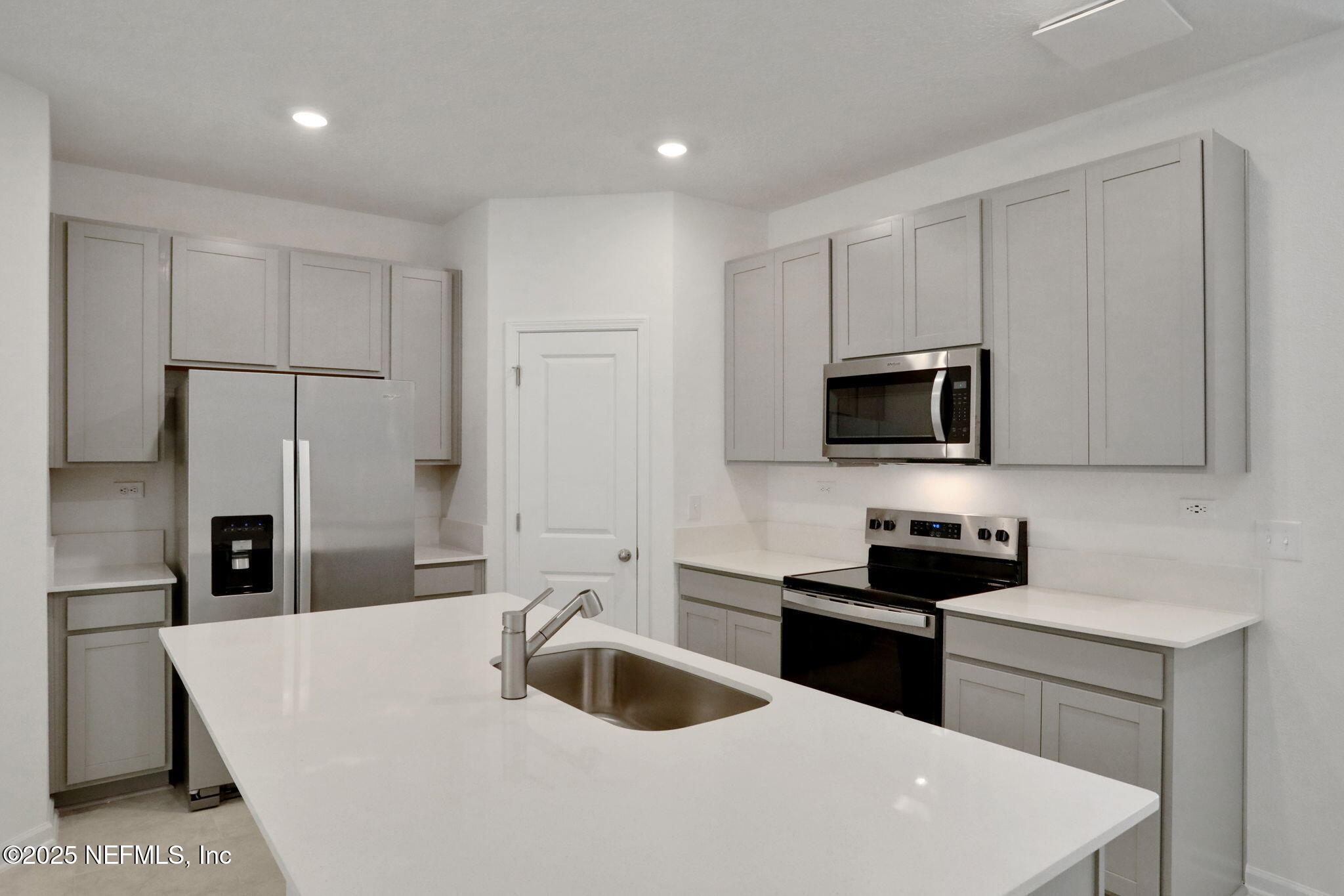 3769 Athenian Way Middleburg, FL 32068 - Photo 6 of 31 a kitchen with stainless steel appliances a sink a stove a microwave and cabinets
