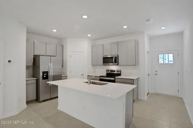 a kitchen with stainless steel appliances a refrigerator stove microwave and sink