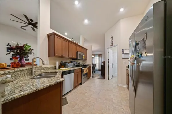 a kitchen with stainless steel appliances granite countertop a refrigerator sink and stove