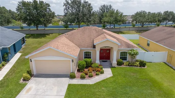 a aerial view of a house with swimming pool next to a yard