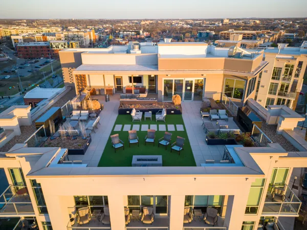 a living room with couches a dining table and chairs with wooden floor