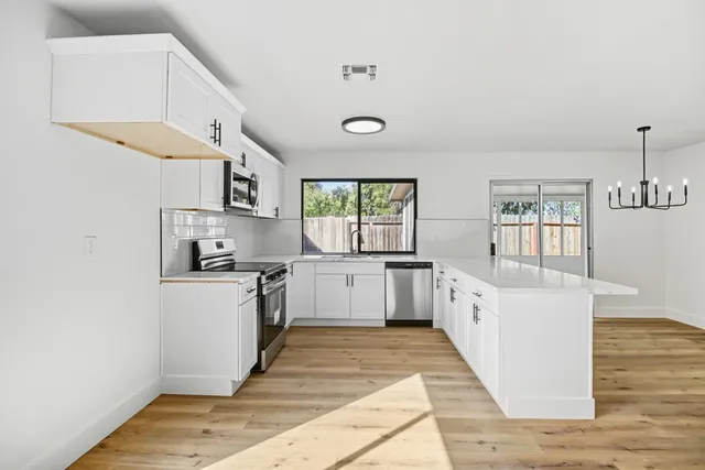 a large kitchen with a lot of counter space and wooden floor