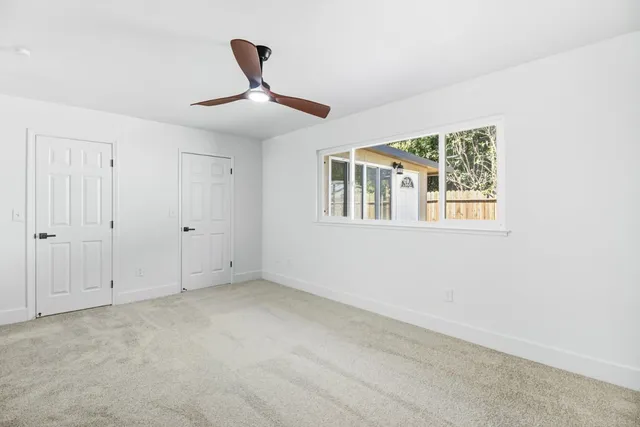 a view of an empty room with a ceiling fan