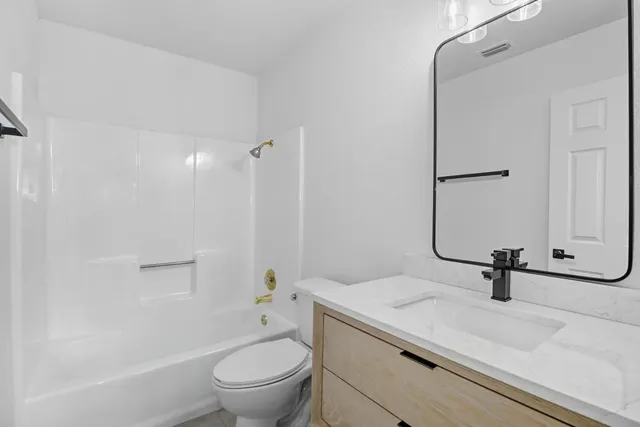 a bathroom with a sink a toilet and a mirror