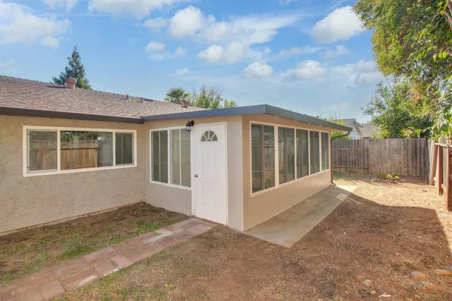 a view of backyard with deck and wooden fence
