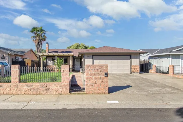 a front view of a house with a garden and plants