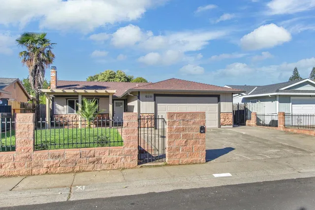 a front view of a house with a garden and plants