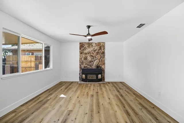 a view of empty room with wooden floor and ceiling fan